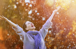 happy beautiful young woman under the autumn shower. girl is enjoying rainfall.