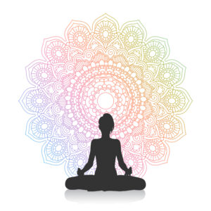 silhouette of female in yoga pose against mandala design