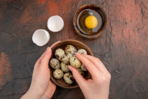top view fresh quail eggs with raw egg inside plate dark table