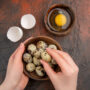 top view fresh quail eggs with raw egg inside plate dark table