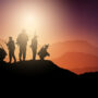 silhouettes of soldiers on lookout in sunset landscape