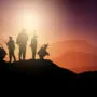 silhouettes of soldiers on lookout in sunset landscape