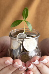 person holding jar coins hands