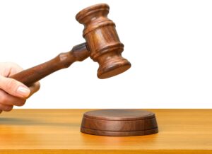 someones hand holding wooden law gavel