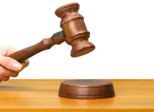 someones hand holding wooden law gavel