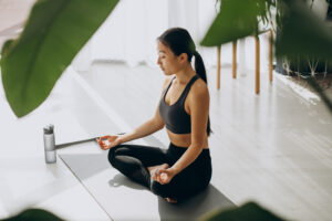 woman practicing yoga on mat at home