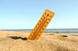 selective focus shot of a thermometer in the beach sand with a blurred background