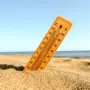 selective focus shot of a thermometer in the beach sand with a blurred background